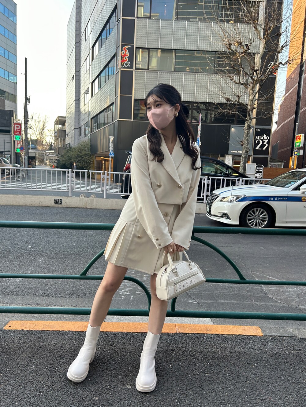 ホワイト系のテーラードジャケット、ホワイト系のワンピース、ホワイト系のブーツを着用したレディースの冬コーディネートの2枚目の写真