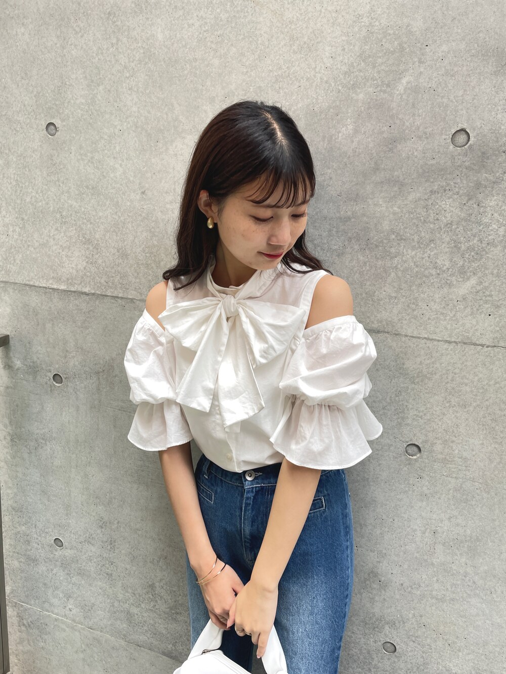 ホワイト系のシャツ/ブラウス、ブルー系のデニムパンツ、ホワイト系のハンドバッグを着用したレディースの夏コーディネートの2枚目の写真