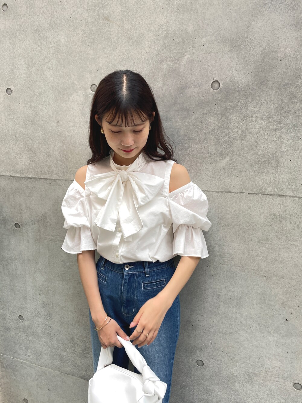 ホワイト系のシャツ/ブラウス、ブルー系のデニムパンツ、ホワイト系のハンドバッグを着用したレディースの夏コーディネートの3枚目の写真