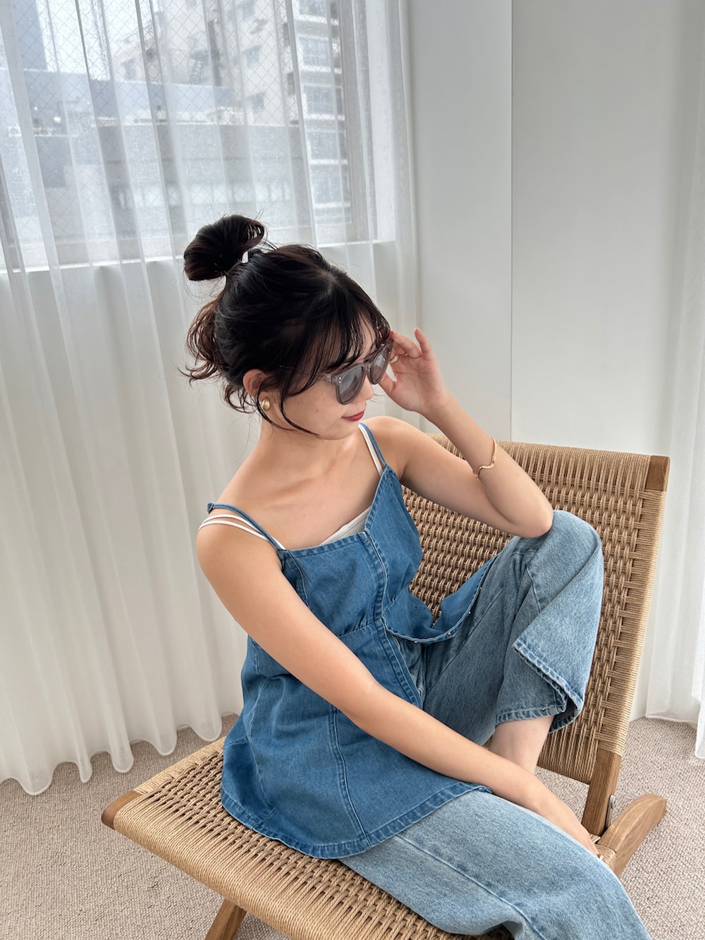 ブルー系のトップス、ブルー系のデニムパンツ、グレー系のサングラスを着用したレディースの夏コーディネートの2枚目の写真