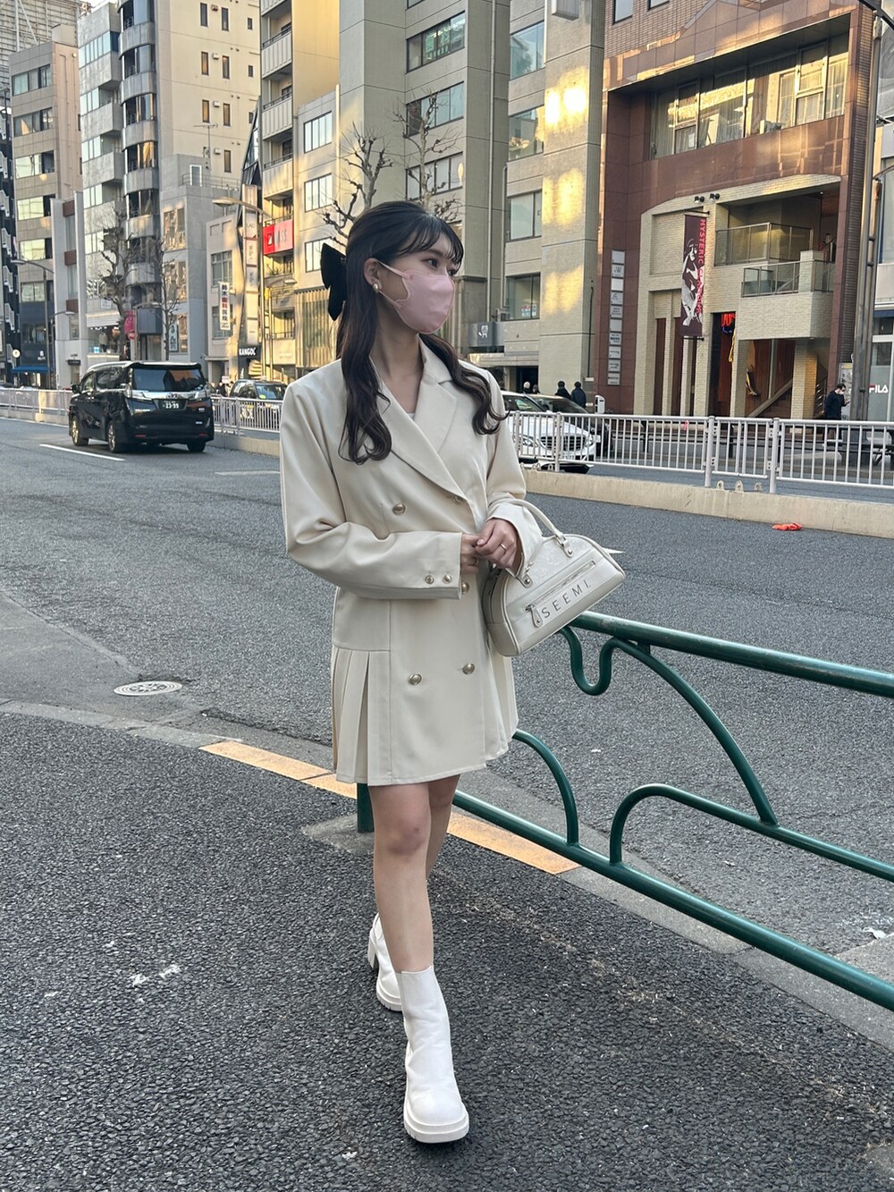 ホワイト系のテーラードジャケット、ホワイト系のワンピース、ホワイト系のブーツを着用したレディースの冬コーディネートの3枚目の写真