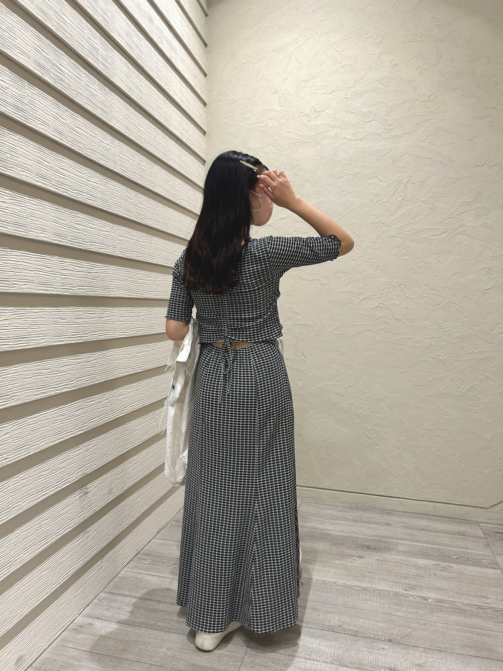 ブラック系のワンピース、ホワイト系のテーラードジャケット、ホワイト系のショルダーバッグを着用したレディースの春コーディネートの3枚目の写真