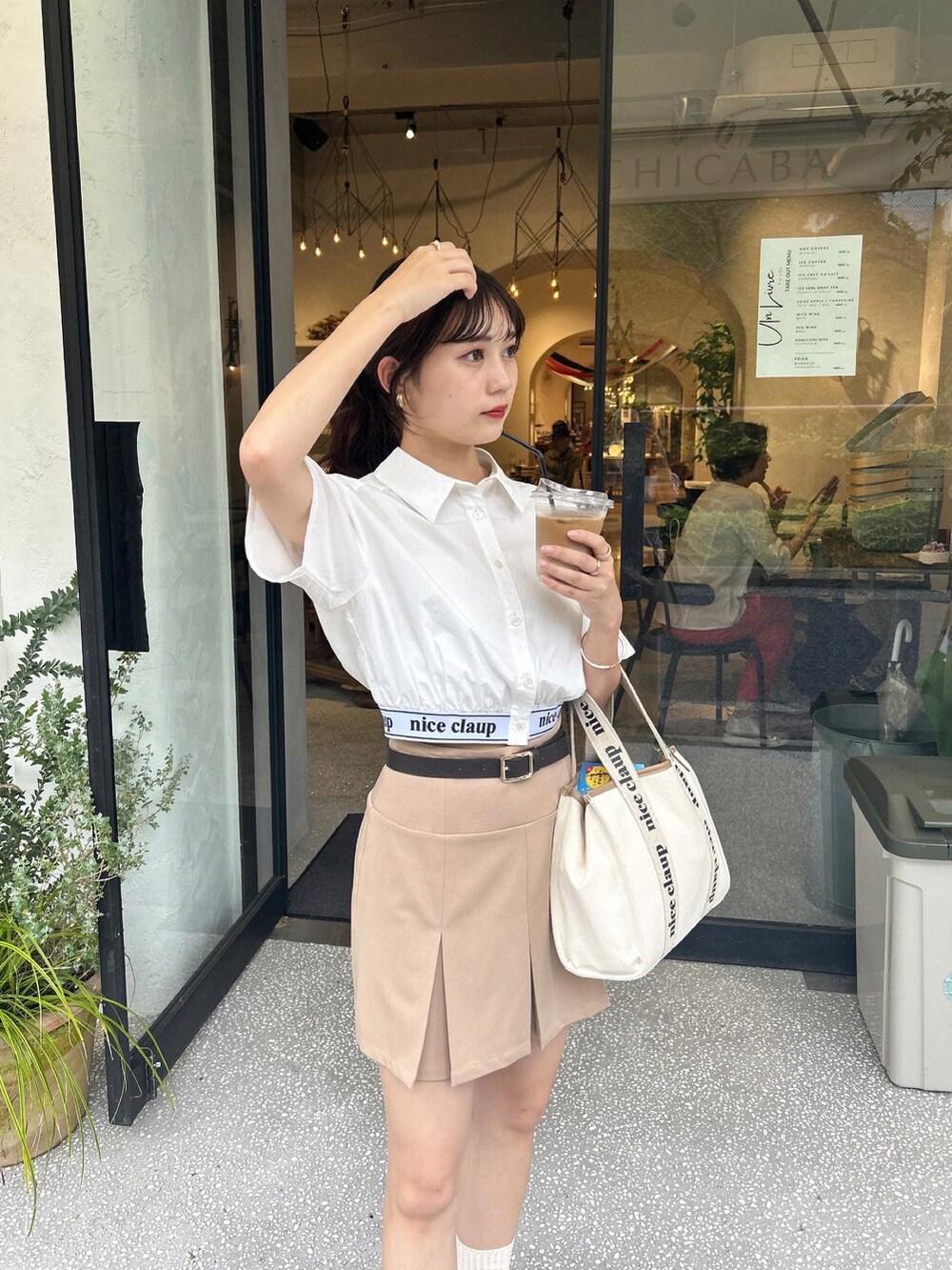 ホワイト系のシャツ/ブラウス、ベージュ系のスカート、ホワイト系のスニーカーを着用したレディースの夏コーディネートの3枚目の写真