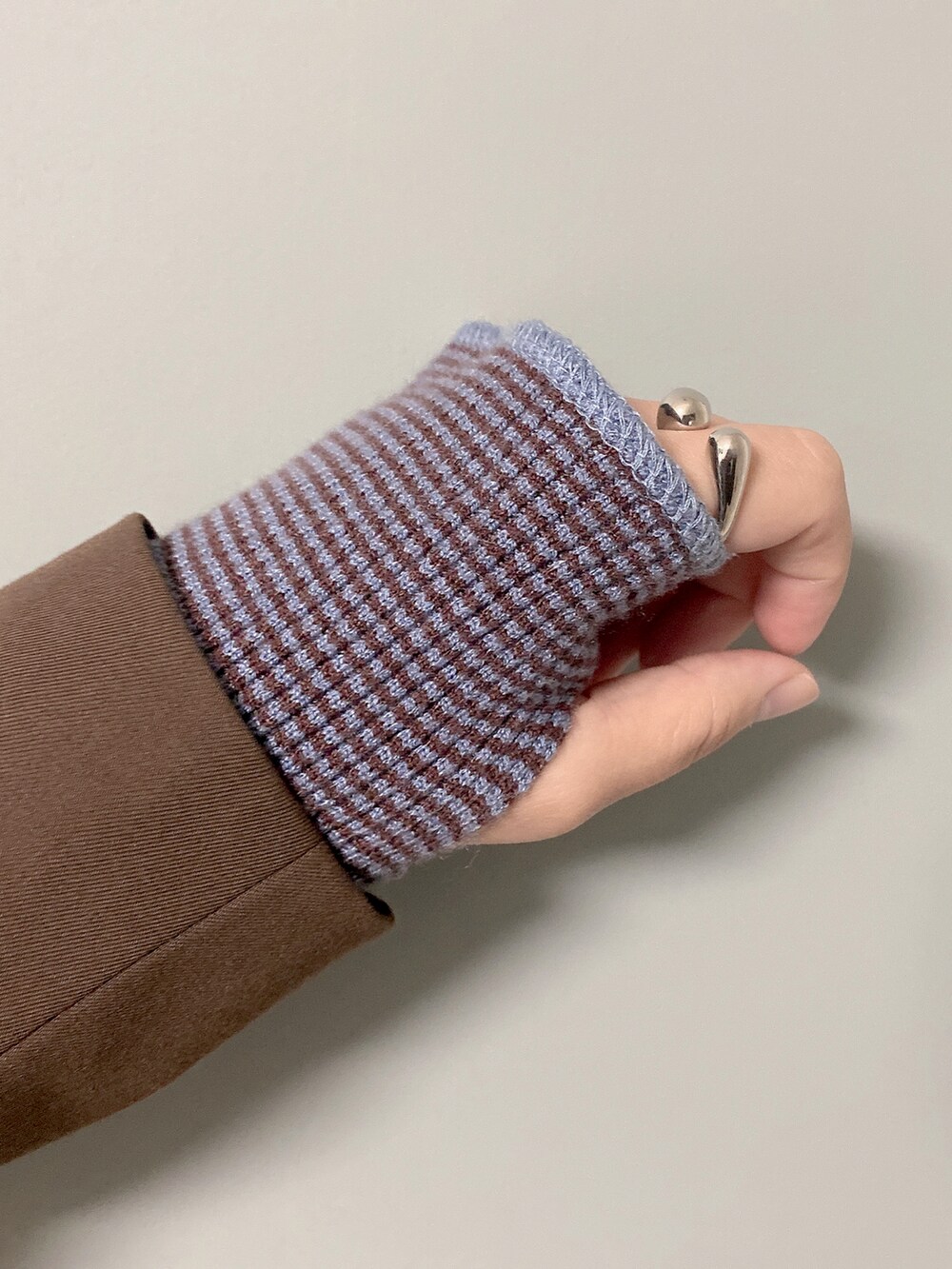 ブルー系のニット/セーター、ブラック系のスカート、ブラウン系のジャケット/アウターを着用したレディースの秋コーディネートの2枚目の写真