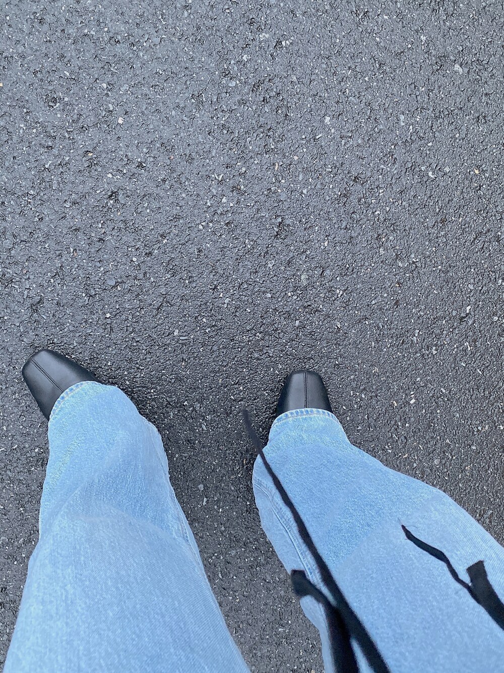 ブルー系のデニムパンツ、ブラック系のシャツ/ブラウス、ブラウン系のバッグを着用したレディースの秋コーディネートの2枚目の写真