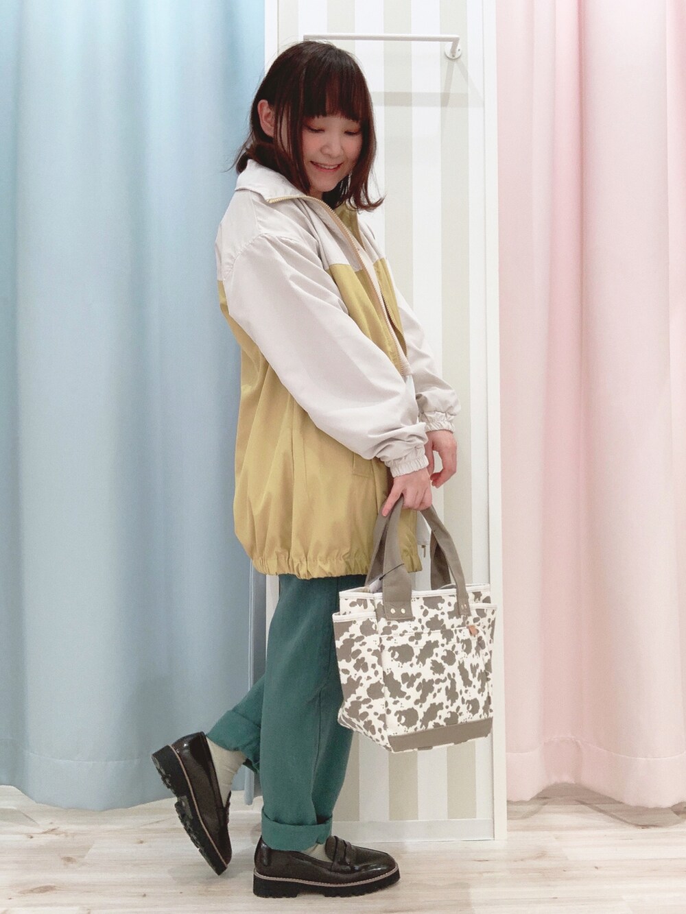 ベージュ系のスウェット、イエロー系のブルゾン、グリーン系のデニムパンツを着用したレディースの春コーディネートの2枚目の写真