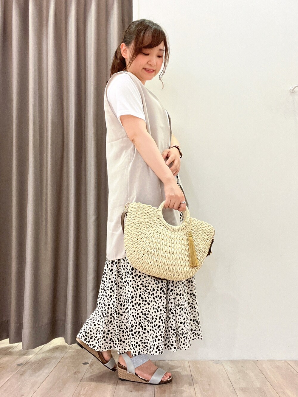 ホワイト系のショルダーバッグ、ホワイト系のスカート、シルバー系のサンダルを着用したレディースの夏コーディネートの2枚目の写真