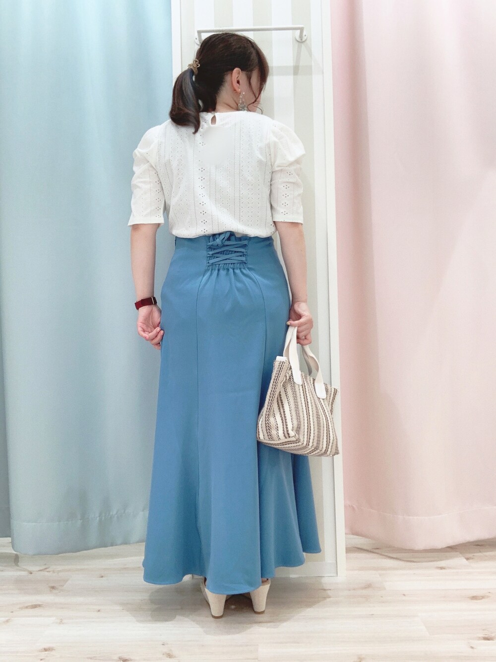 ブルー系のスカート、ベージュ系のトートバッグ、ベージュ系のサンダルを着用したレディースの夏コーディネートの3枚目の写真