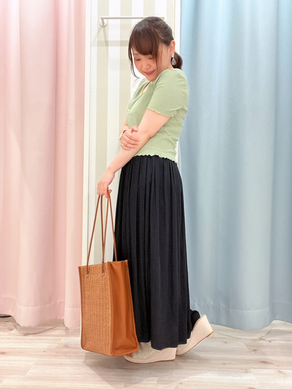 ブルー系のスカート、オレンジ系のトートバッグ、ベージュ系のサンダルを着用したレディースの夏コーディネートの2枚目の写真