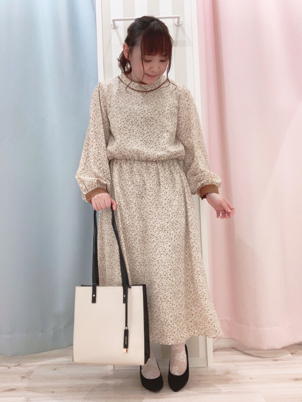 ホワイト系のブルゾン、ベージュ系のワンピース、ベージュ系のトートバッグを着用したレディースの春コーディネートの3枚目の写真