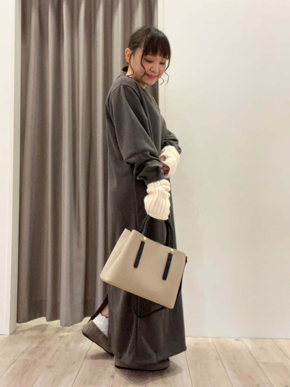 グレー系のワンピース、ベージュ系のトートバッグ、ベージュ系のその他シューズを着用したレディースの冬コーディネートの2枚目の写真