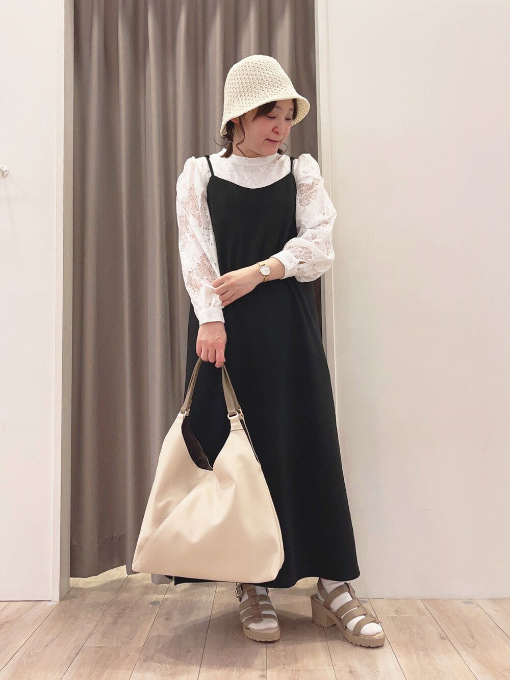 グリーン系のカーディガン/ボレロ、ホワイト系のトートバッグ、ベージュ系のサンダルを着用したレディースの春コーディネートの2枚目の写真