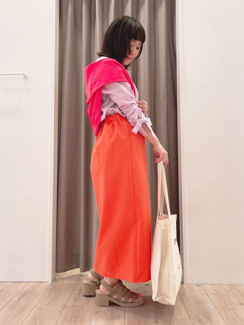 ピンク系のシャツ/ブラウス、ピンク系のカーディガン/ボレロ、ブラック系のスカートを着用したレディースの春コーディネートの2枚目の写真