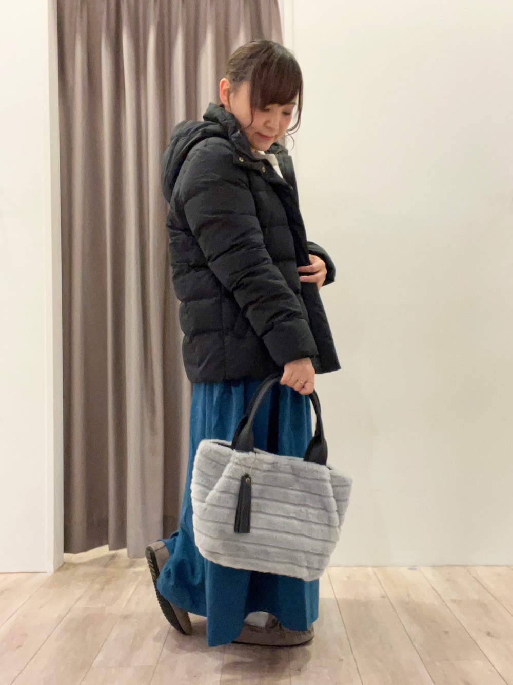 グレー系のトートバッグ、ベージュ系のその他シューズ、ブルー系のスカートを着用したレディースの冬コーディネートの2枚目の写真