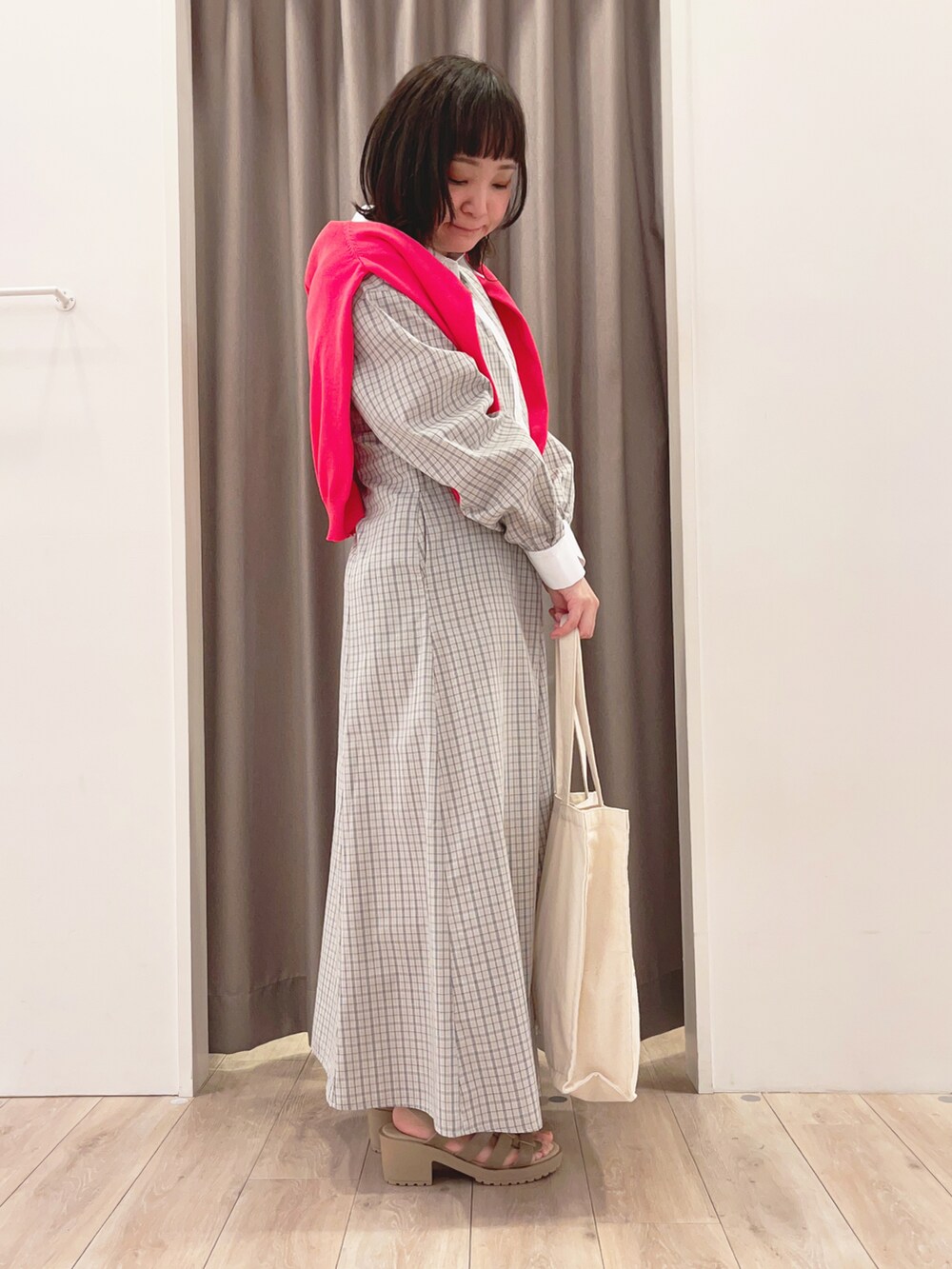 ピンク系のカーディガン/ボレロ、ホワイト系のワンピース、ホワイト系のトートバッグを着用したレディースの春コーディネートの2枚目の写真