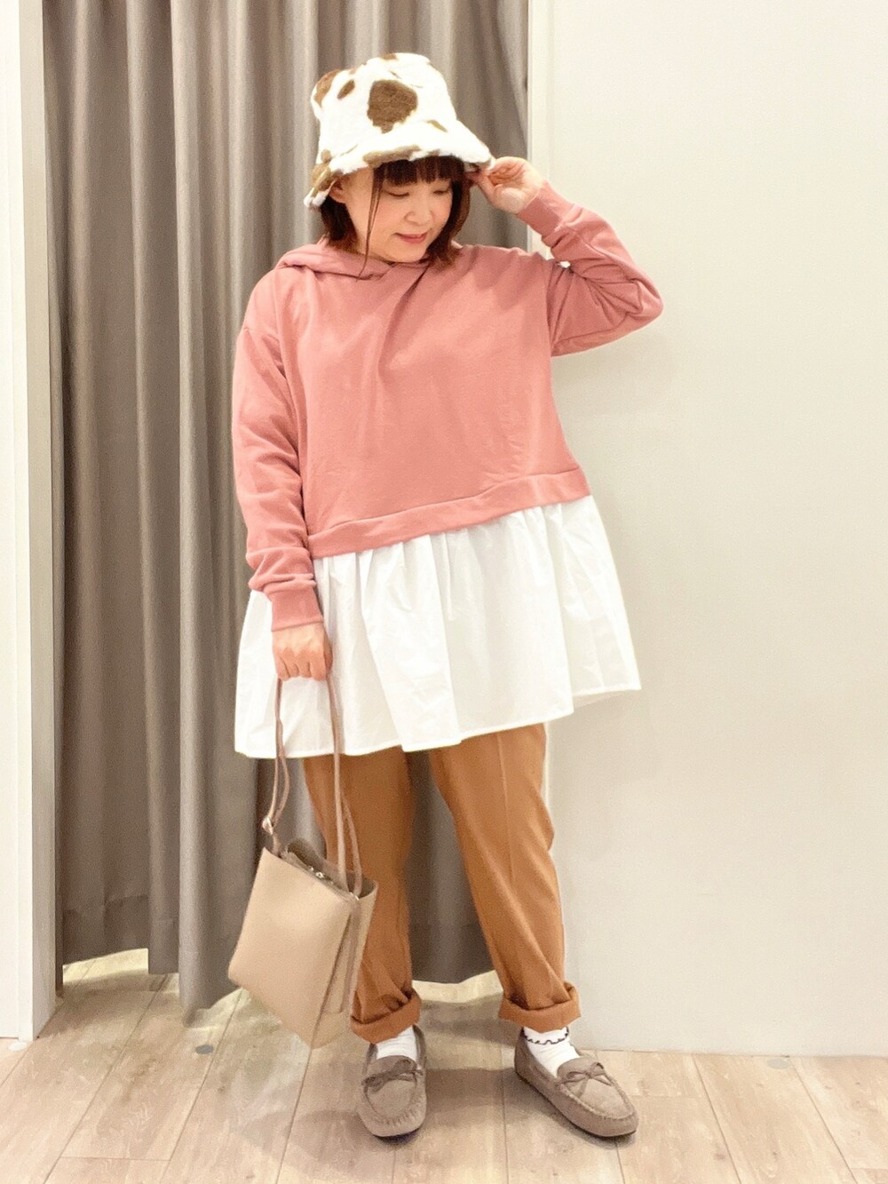 ピンク系のチュニック、ベージュ系のブルゾン、ブラウン系のその他パンツを着用したレディースの秋コーディネートの3枚目の写真