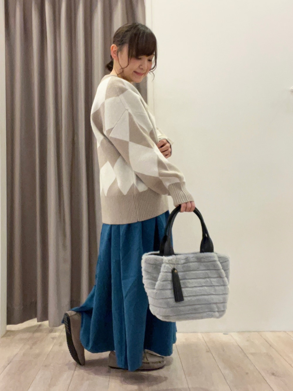 グレー系のトートバッグ、ベージュ系のその他シューズ、ブルー系のスカートを着用したレディースの冬コーディネートの4枚目の写真