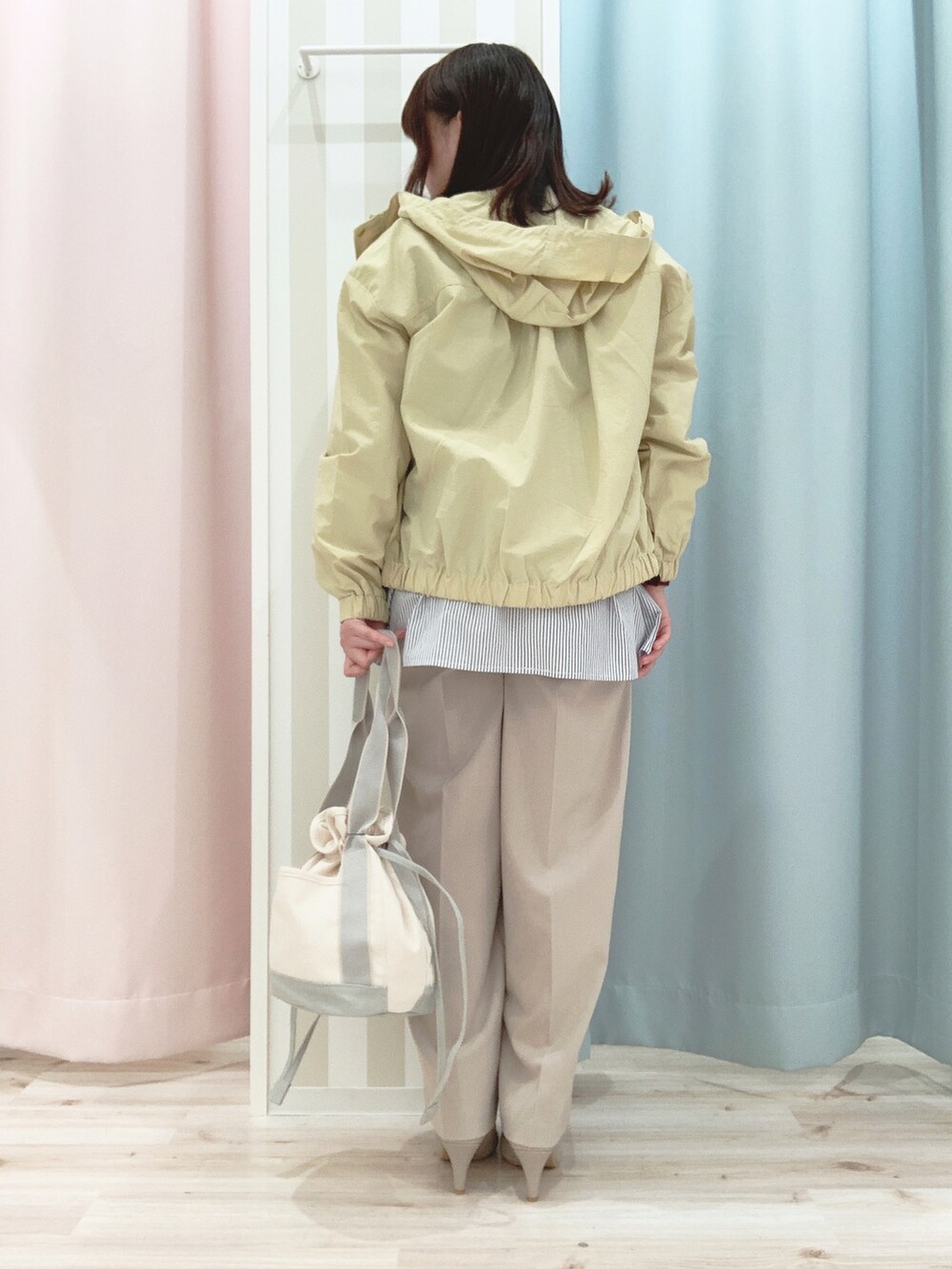 イエロー系のブルゾン、グリーン系のTシャツ/カットソー、ベージュ系のその他パンツを着用したレディースの春コーディネートの3枚目の写真