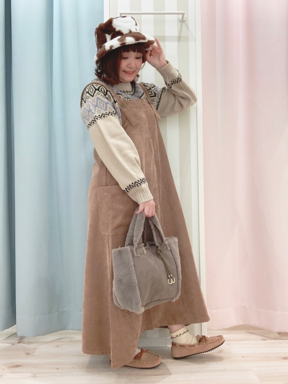 ブラウン系のブルゾン、ベージュ系のニット/セーター、イエロー系のスカートを着用したレディースの冬コーディネートの2枚目の写真