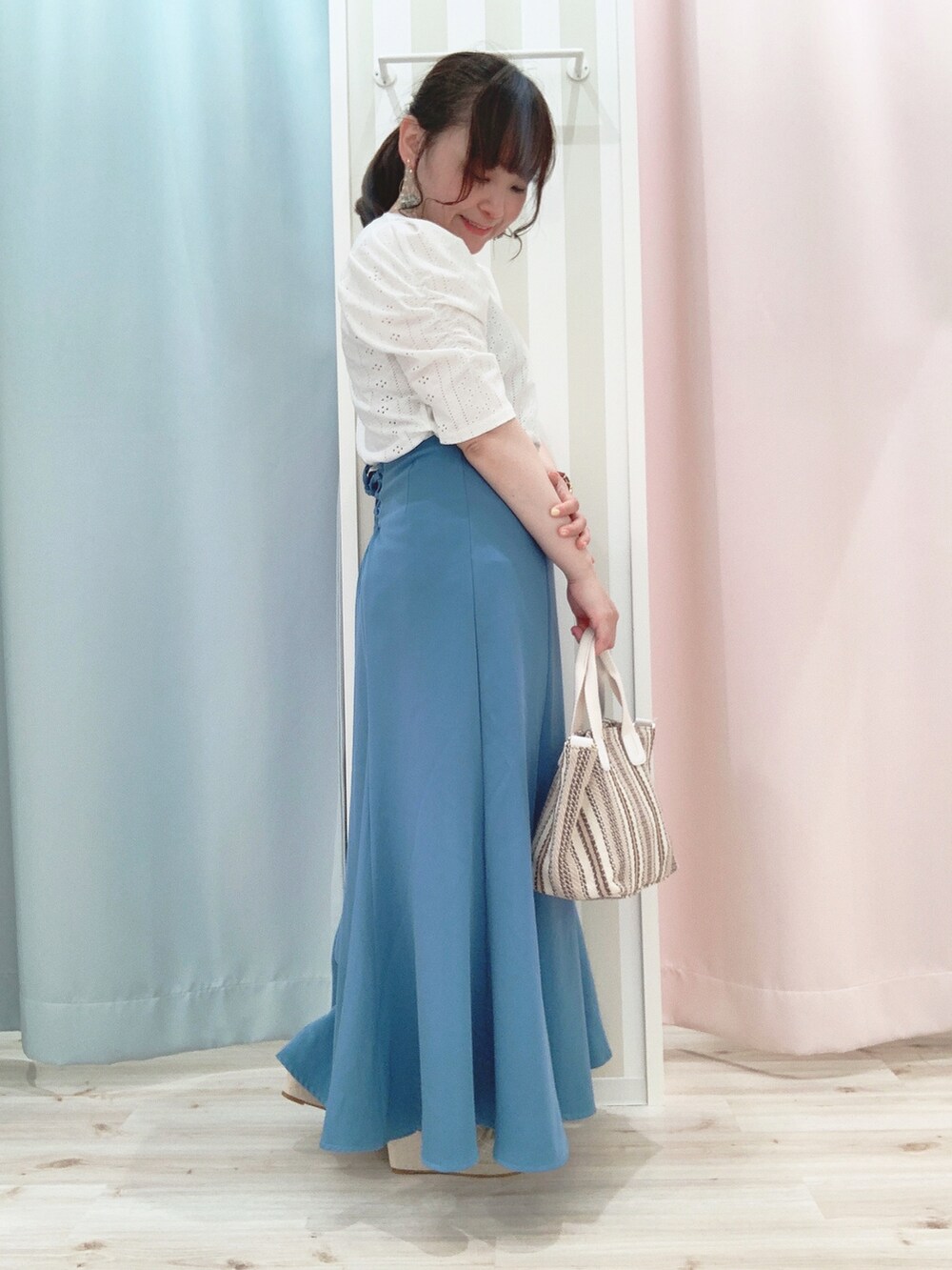 ブルー系のスカート、ベージュ系のトートバッグ、ベージュ系のサンダルを着用したレディースの夏コーディネートの2枚目の写真