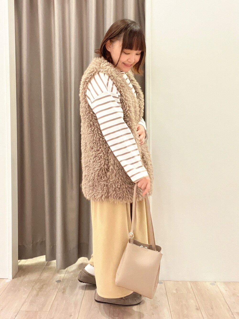 ブラウン系のベスト、ベージュ系のその他パンツ、ベージュ系のその他シューズを着用したレディースの秋コーディネートの2枚目の写真