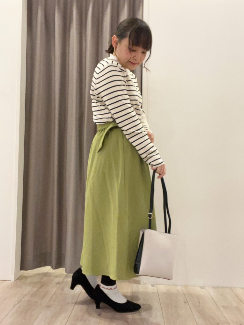 ホワイト系のTシャツ/カットソー、グリーン系のスカート、グレー系のショルダーバッグを着用したレディースの春コーディネートの4枚目の写真