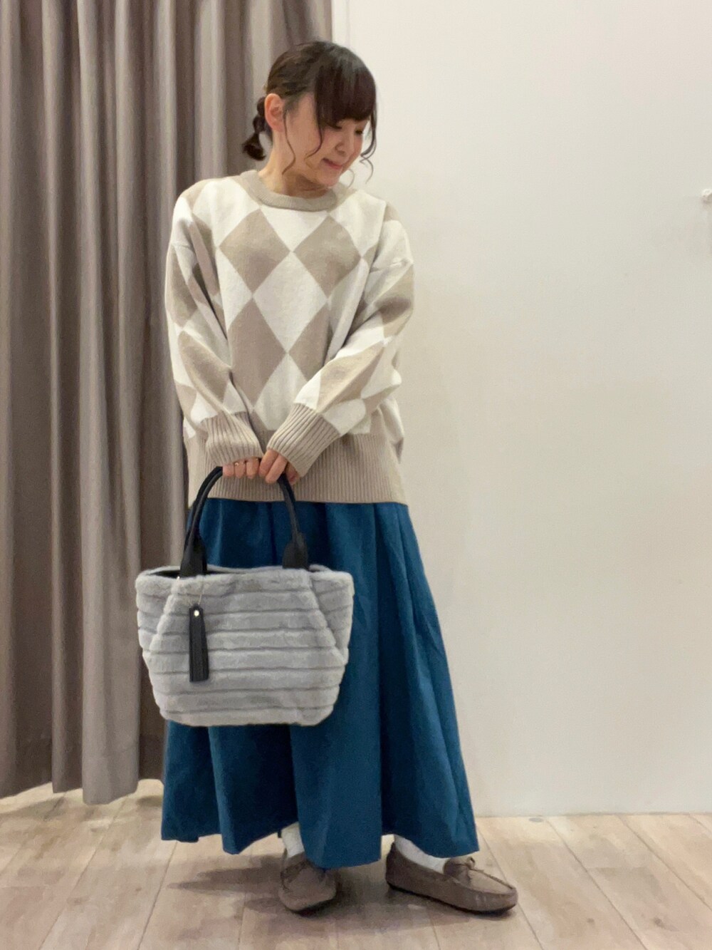 グレー系のトートバッグ、ベージュ系のその他シューズ、ブルー系のスカートを着用したレディースの冬コーディネートの3枚目の写真