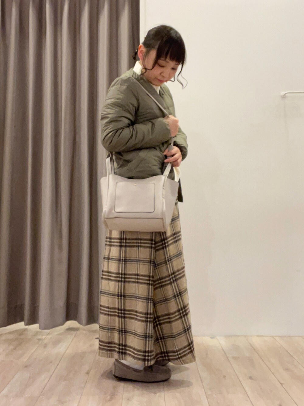 グリーン系のダウンジャケット/コート、ブルー系のスカート、ベージュ系のその他シューズを着用したレディースの冬コーディネートの2枚目の写真