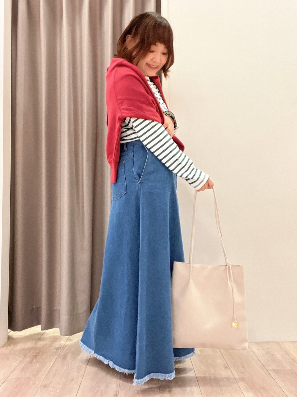 ピンク系のカーディガン/ボレロ、グリーン系のTシャツ/カットソー、ブルー系のデニムスカートを着用したレディースの秋コーディネートの2枚目の写真