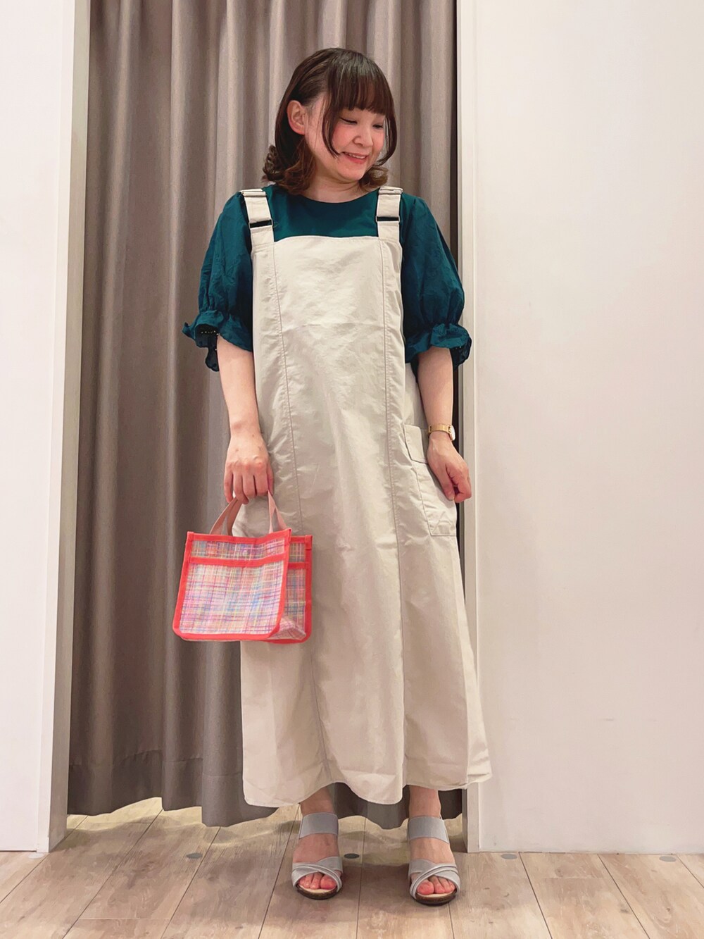 ベージュ系のスカート、グリーン系のTシャツ/カットソー、シルバー系のサンダルを着用したレディースの春コーディネートの2枚目の写真