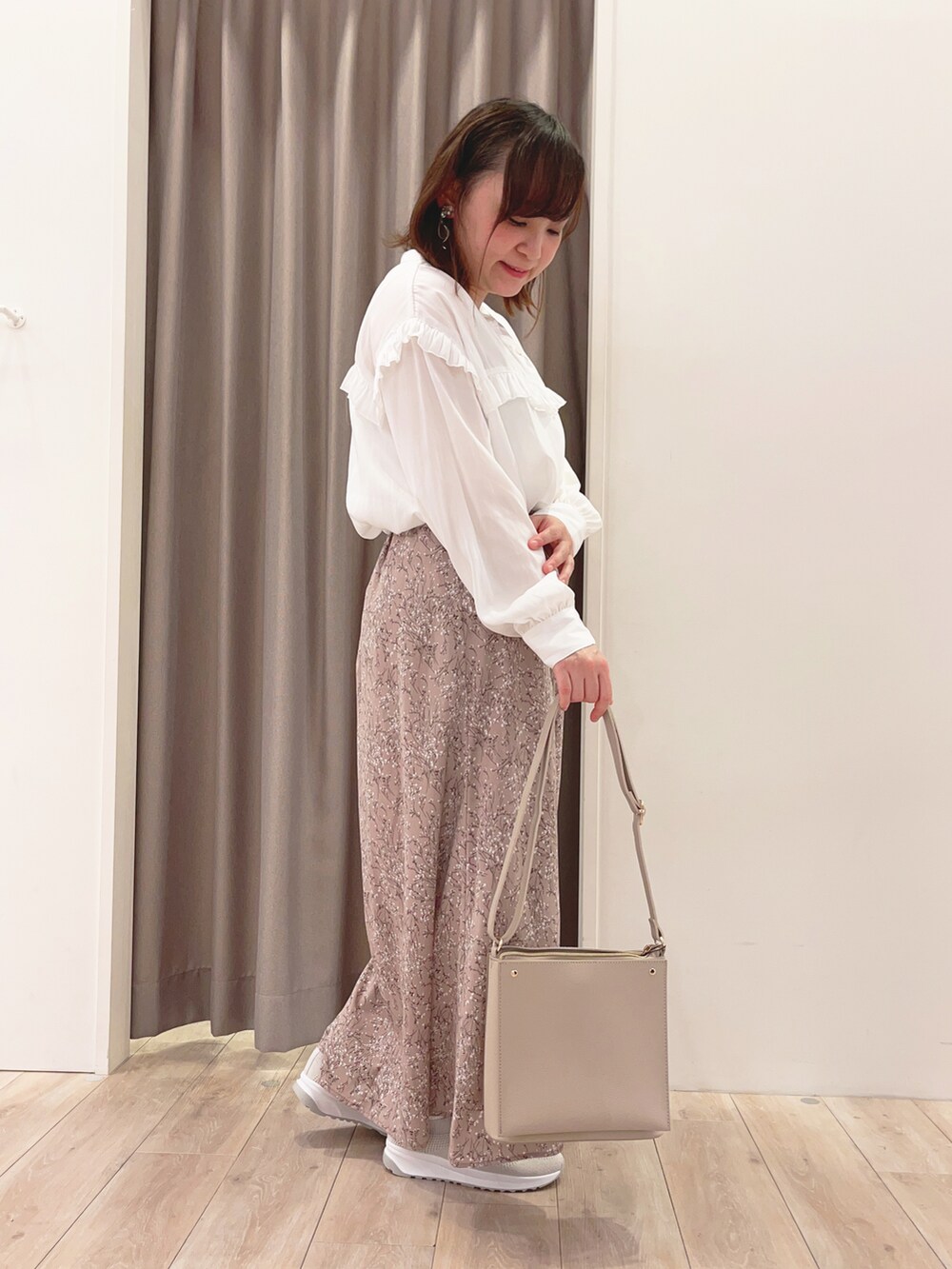 ホワイト系のシャツ/ブラウス、ホワイト系のスカート、ホワイト系のショルダーバッグを着用したレディースの春コーディネートの2枚目の写真