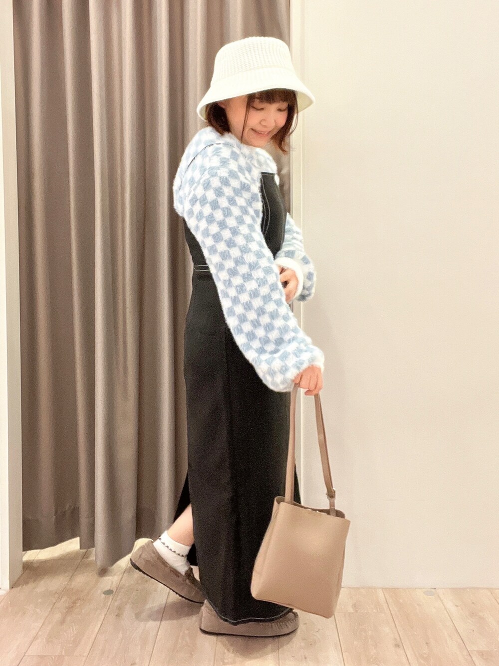 ブラック系のワンピース、ブルー系のニット/セーター、グレー系のショルダーバッグを着用したレディースの秋コーディネートの2枚目の写真