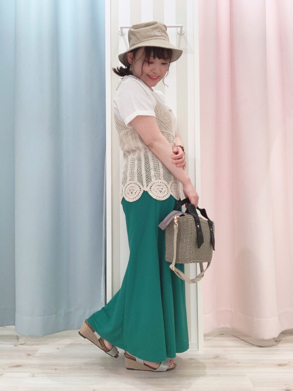 グレー系のショルダーバッグ、グリーン系のスカート、グレー系のサンダルを着用したレディースの春コーディネートの2枚目の写真