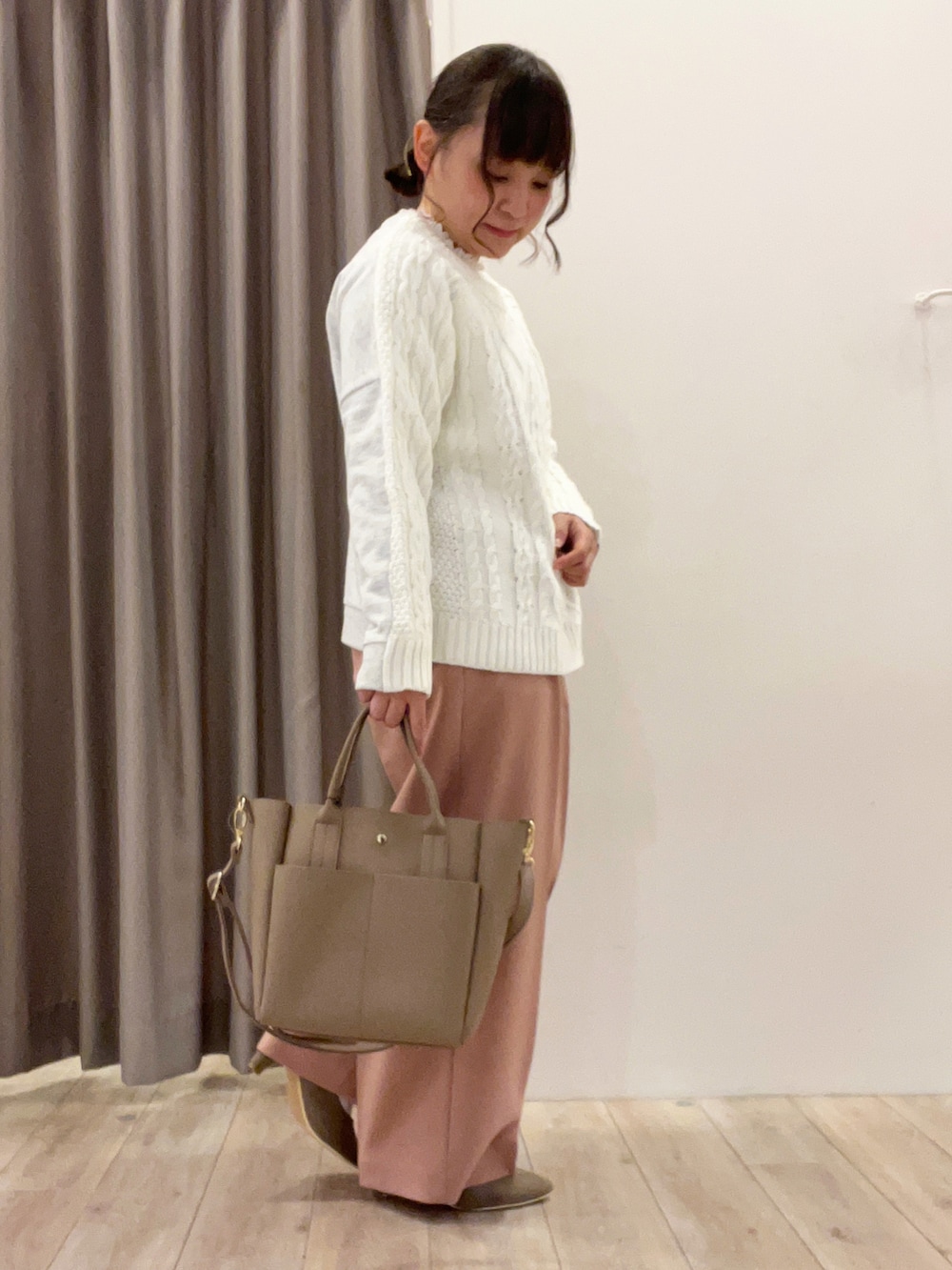 イエロー系のニット/セーター、ピンク系のその他パンツ、ベージュ系のトートバッグを着用したレディースの春コーディネートの2枚目の写真