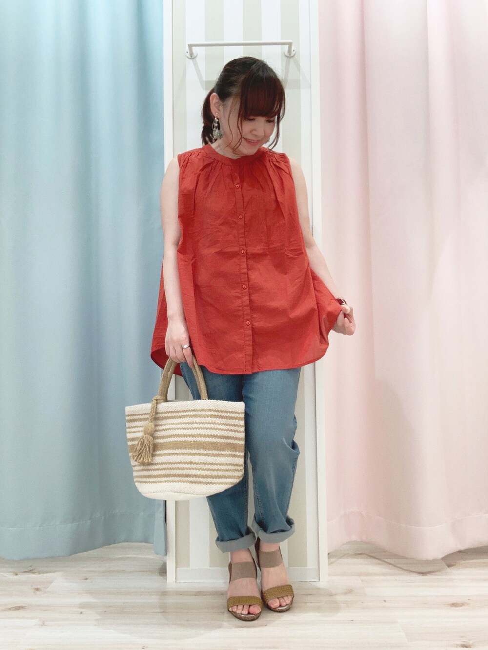 オレンジ系のシャツ/ブラウス、ホワイト系のカーディガン/ボレロ、イエロー系のトートバッグを着用したレディースの春コーディネートの3枚目の写真