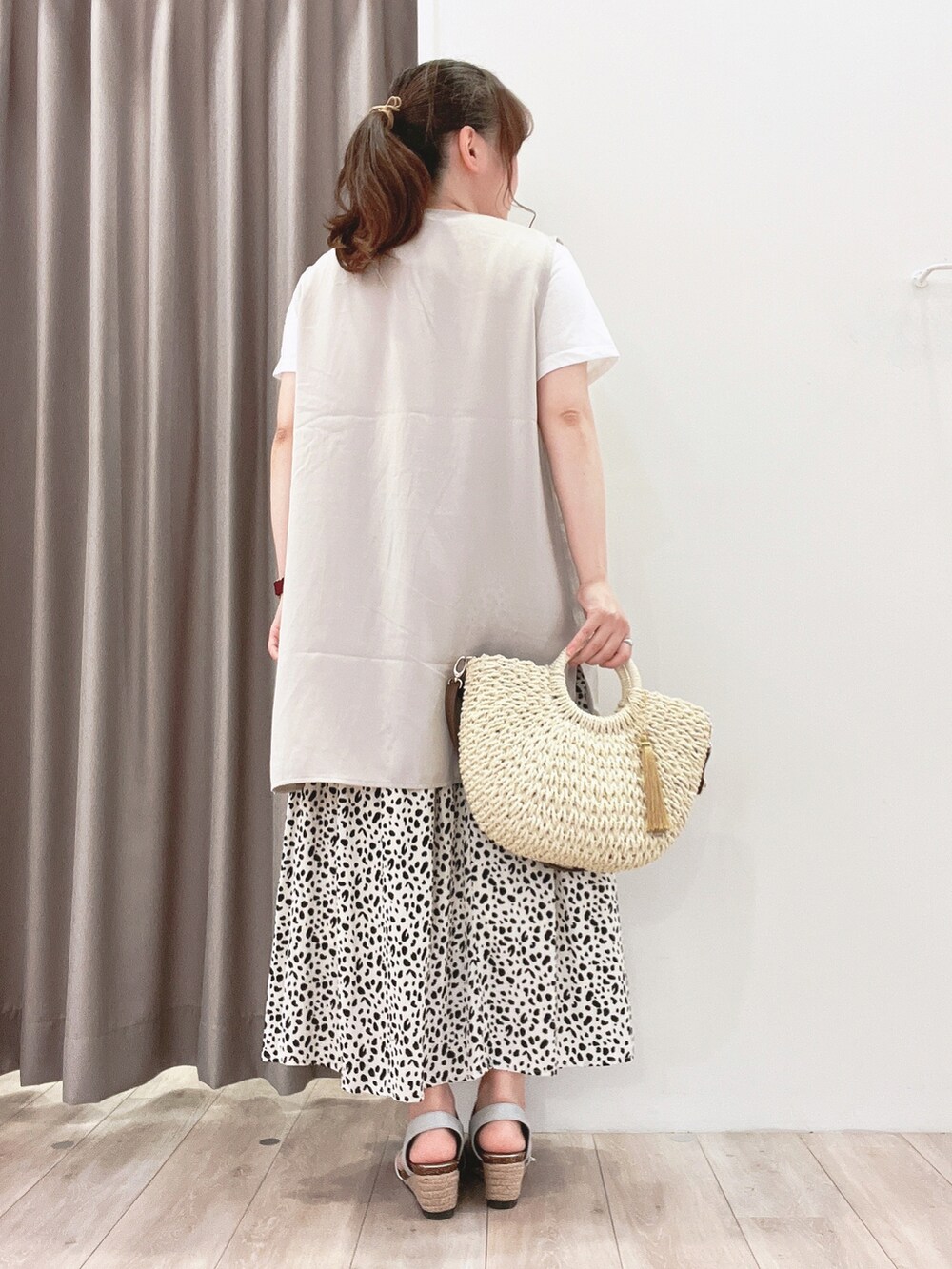 ホワイト系のショルダーバッグ、ホワイト系のスカート、シルバー系のサンダルを着用したレディースの夏コーディネートの3枚目の写真