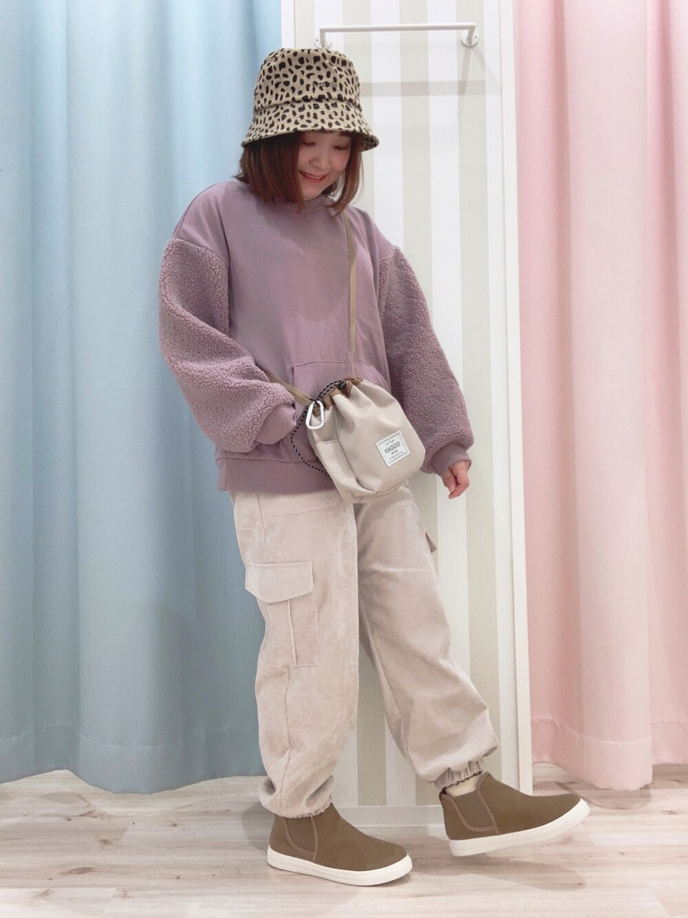 ホワイト系のブルゾン、パープル系のスウェット、ベージュ系のショルダーバッグを着用したレディースの冬コーディネートの4枚目の写真