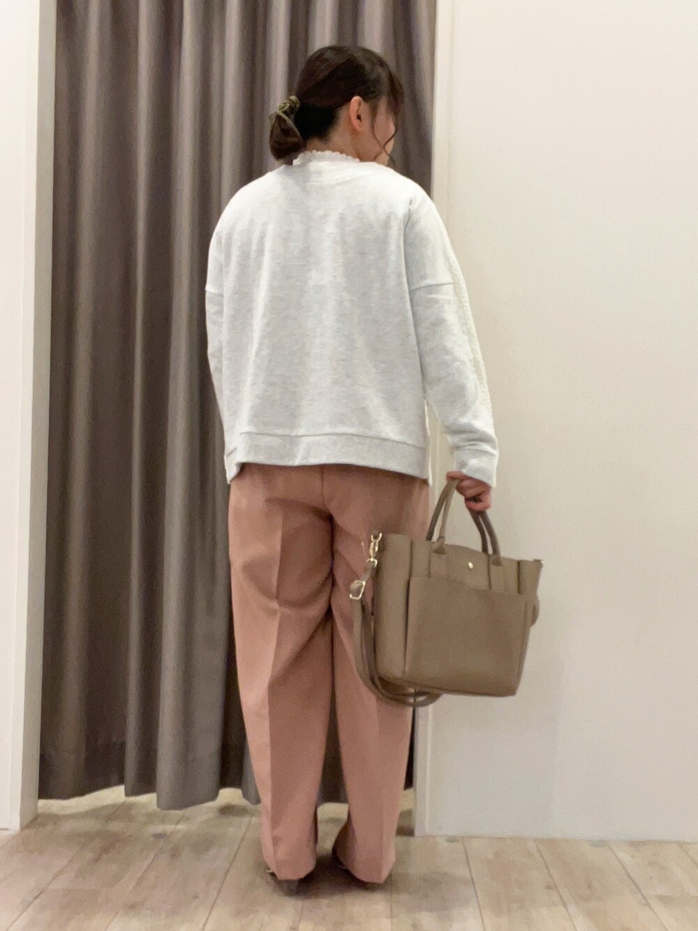 イエロー系のニット/セーター、ピンク系のその他パンツ、ベージュ系のトートバッグを着用したレディースの春コーディネートの3枚目の写真