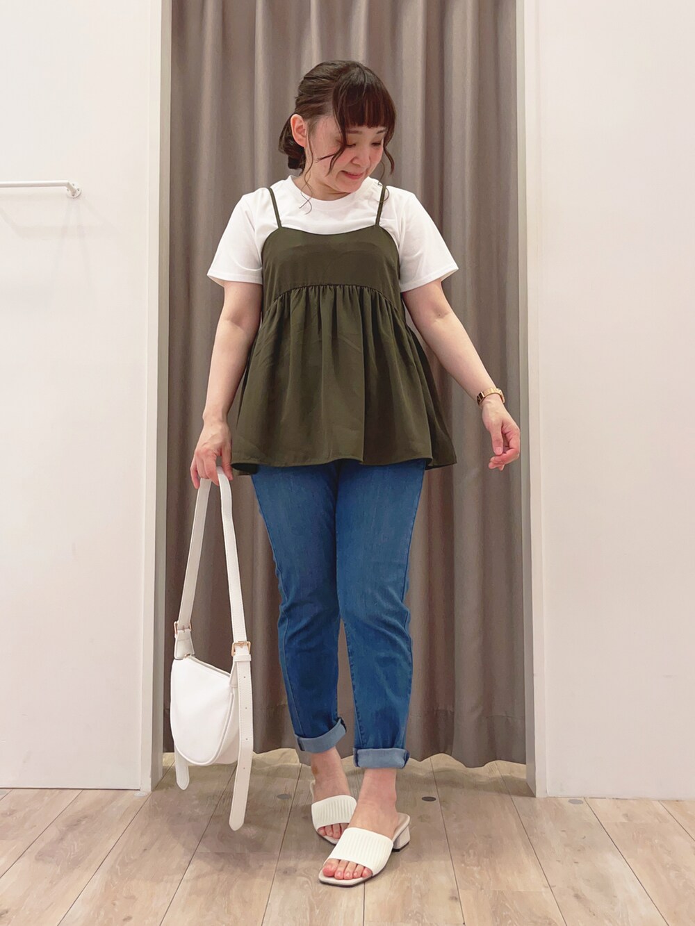 グリーン系のTシャツ/カットソー、ブルー系のデニムパンツ、ホワイト系のショルダーバッグを着用したレディースの夏コーディネートの2枚目の写真