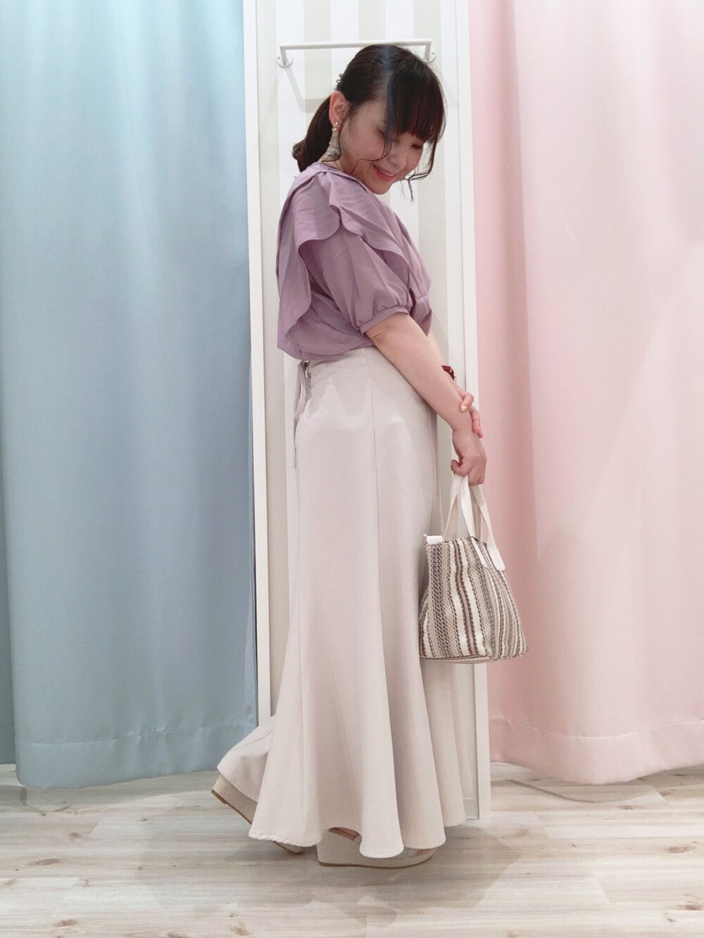 パープル系のシャツ/ブラウス、ベージュ系のスカート、ベージュ系のトートバッグを着用したレディースの夏コーディネートの3枚目の写真