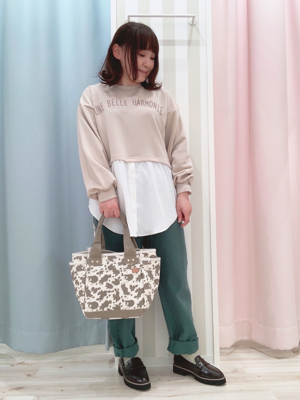 ベージュ系のスウェット、イエロー系のブルゾン、グリーン系のデニムパンツを着用したレディースの春コーディネートの3枚目の写真