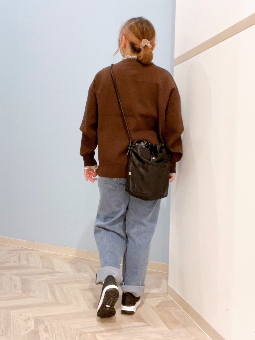 ブラウン系のカーディガン/ボレロ、グレー系のTシャツ/カットソー、ブルー系のデニムパンツを着用したレディースの秋コーディネートの3枚目の写真