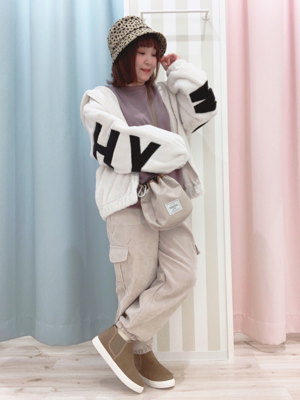 ホワイト系のブルゾン、パープル系のスウェット、ベージュ系のショルダーバッグを着用したレディースの冬コーディネートの3枚目の写真