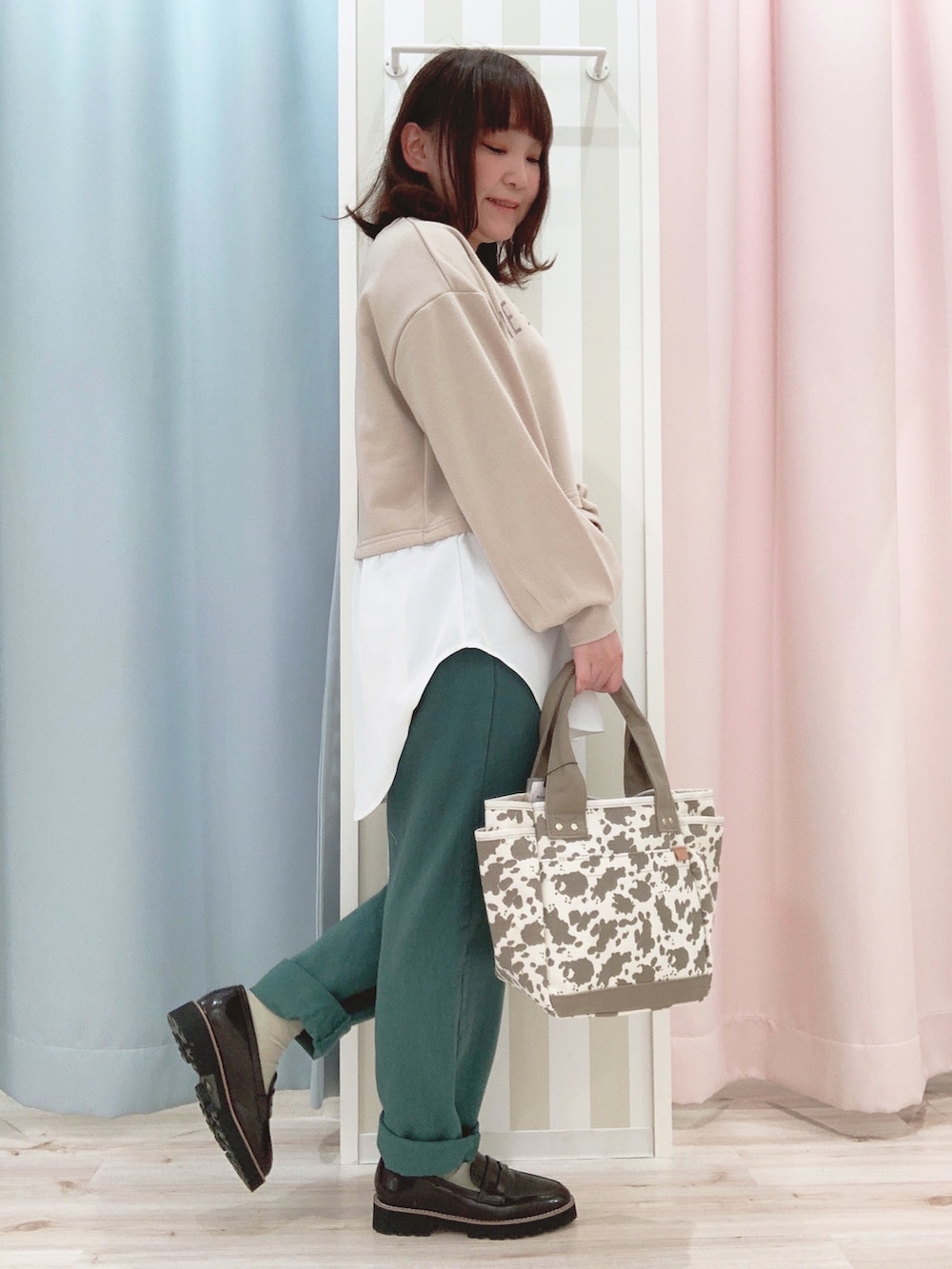 ベージュ系のスウェット、イエロー系のブルゾン、グリーン系のデニムパンツを着用したレディースの春コーディネートの4枚目の写真