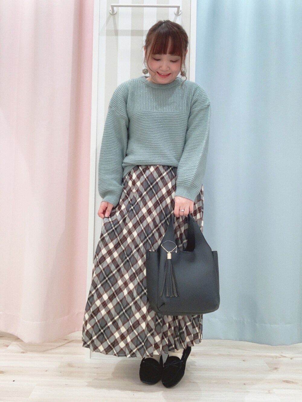 ベージュ系のその他アウター、グリーン系のニット/セーター、レッド系のスカートを着用したレディースの冬コーディネートの3枚目の写真