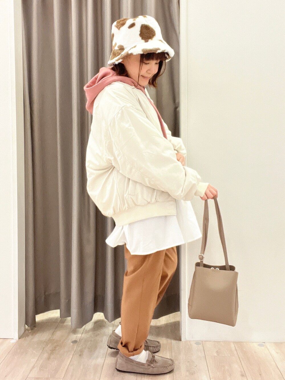 ピンク系のチュニック、ベージュ系のブルゾン、ブラウン系のその他パンツを着用したレディースの秋コーディネートの2枚目の写真