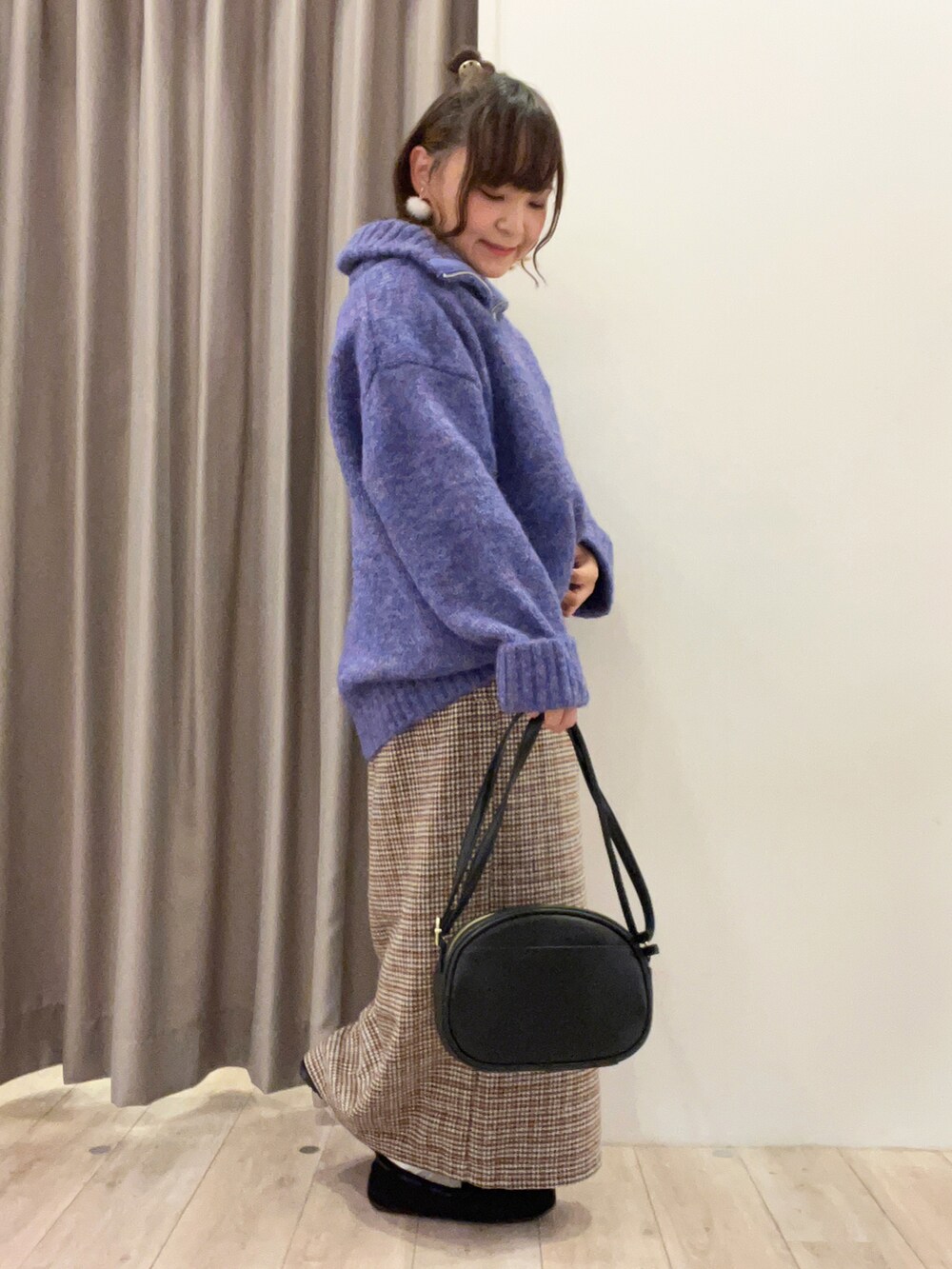 ブルー系のトップス、ベージュ系のスカート、ブラック系のバッグを着用したレディースの冬コーディネートの2枚目の写真