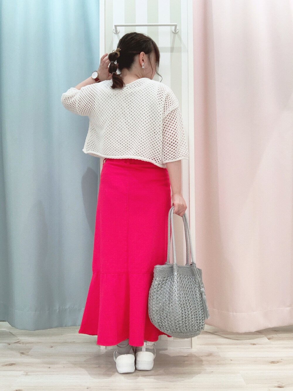 ピンク系のスカート、グレー系のトートバッグ、グレー系のスニーカーを着用したレディースの春コーディネートの2枚目の写真