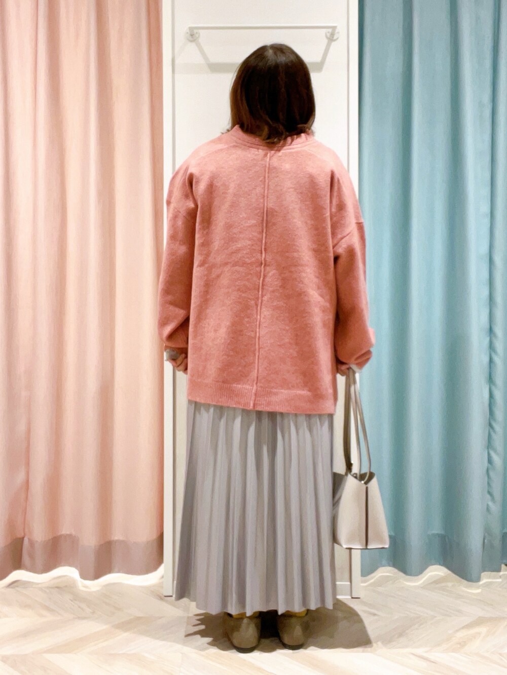 ピンク系のニット/セーター、ホワイト系のTシャツ/カットソー、グレー系のスカートを着用したレディースの冬コーディネートの3枚目の写真