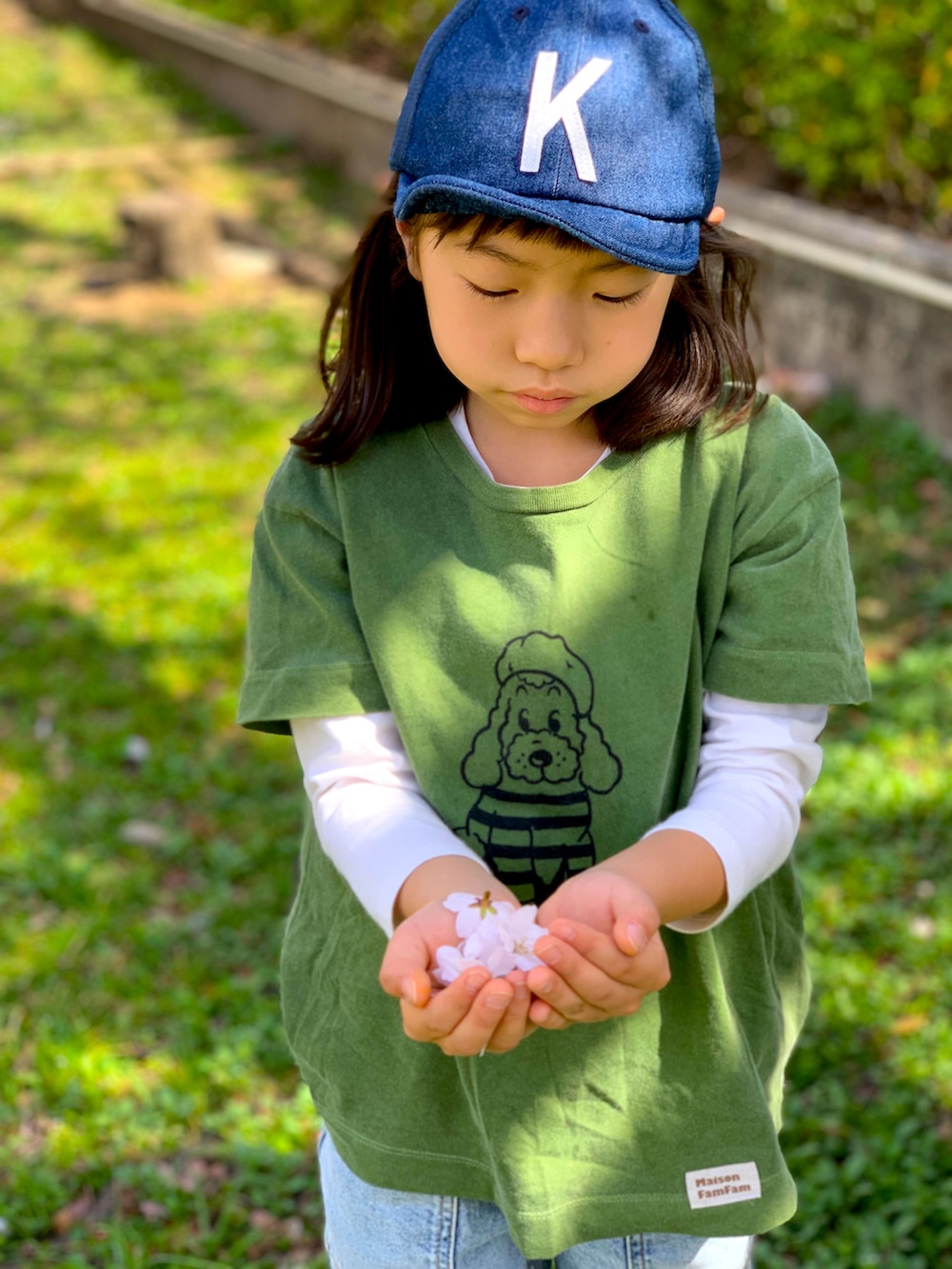 グリーン系のTシャツ/カットソー、ブルー系のデニムパンツ、ブラック系のスニーカーを着用したキッズの春コーディネートの3枚目の写真